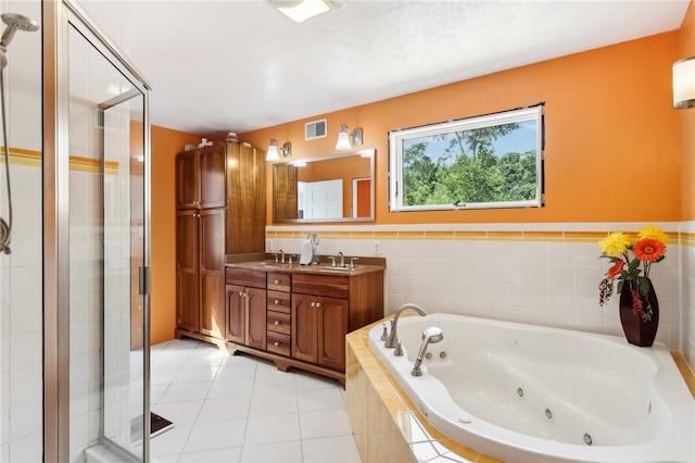 bathroom with independent shower and bath, vanity, and tile patterned flooring