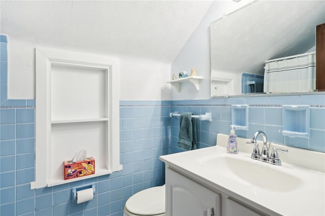 bathroom with vanity, tile walls, toilet, and lofted ceiling