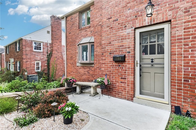 doorway to property with cooling unit and a patio