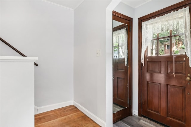 entryway with ornamental molding and hardwood / wood-style flooring