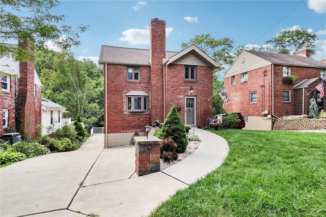 view of front of house with a front yard and central AC unit