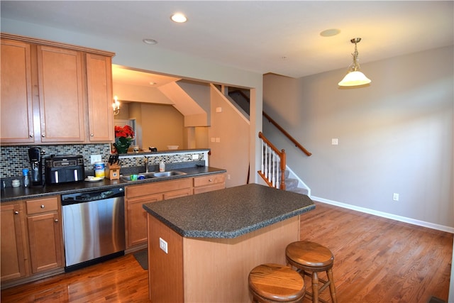 kitchen featuring a kitchen island, dishwasher, sink, and dark hardwood / wood-style flooring