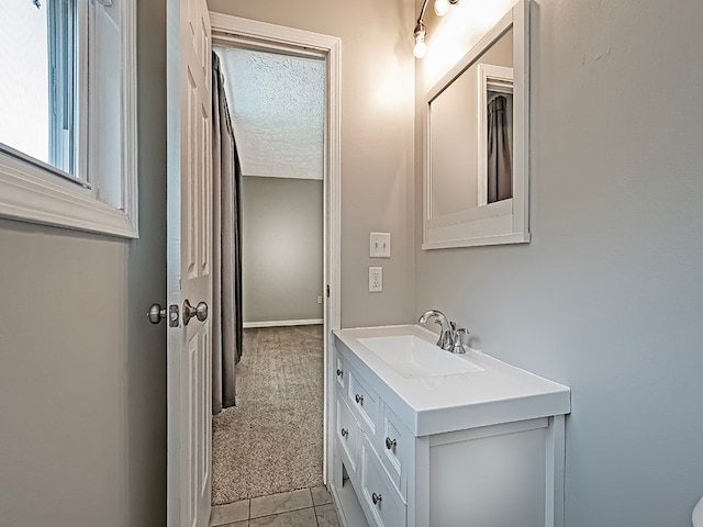 bathroom with vanity, a textured ceiling, and tile patterned flooring