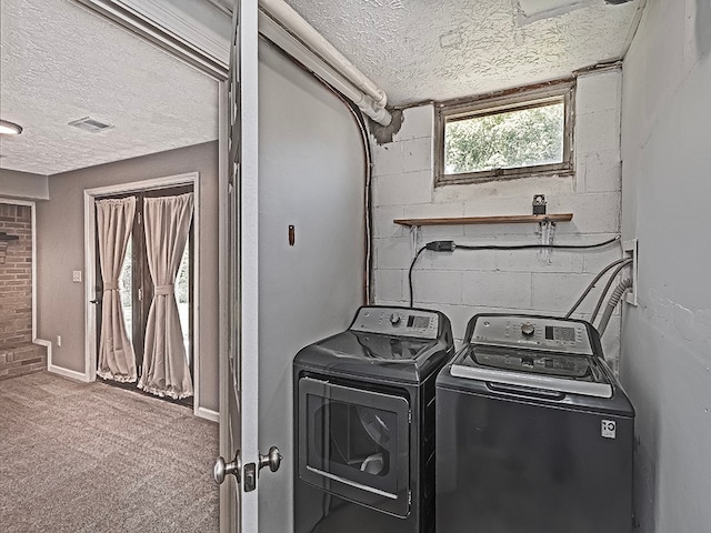 laundry area featuring carpet, independent washer and dryer, and a textured ceiling