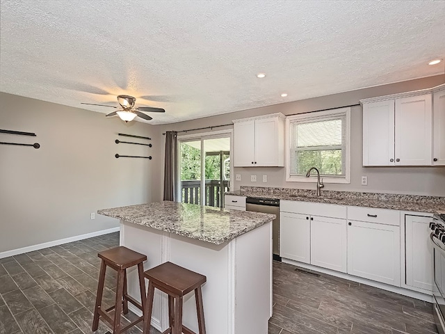 kitchen featuring white cabinetry, a center island, sink, ceiling fan, and appliances with stainless steel finishes