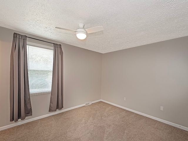 unfurnished room featuring a textured ceiling, ceiling fan, and carpet floors