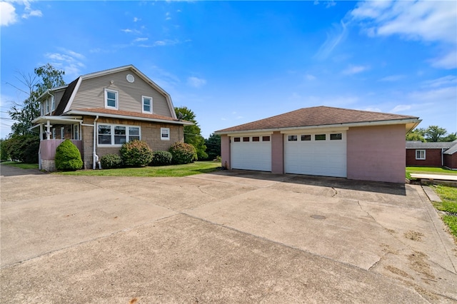 view of front of home featuring a garage and an outbuilding