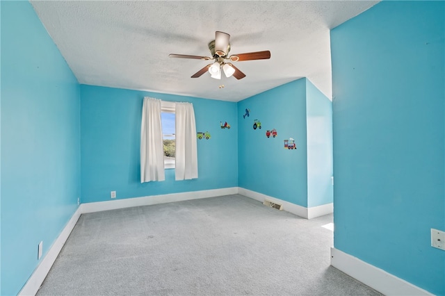 unfurnished room featuring ceiling fan, a textured ceiling, and carpet flooring