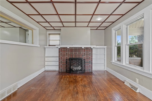 unfurnished living room with a brick fireplace and hardwood / wood-style floors