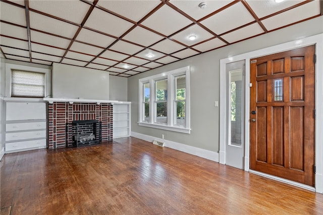 unfurnished living room with a brick fireplace, hardwood / wood-style floors, and coffered ceiling