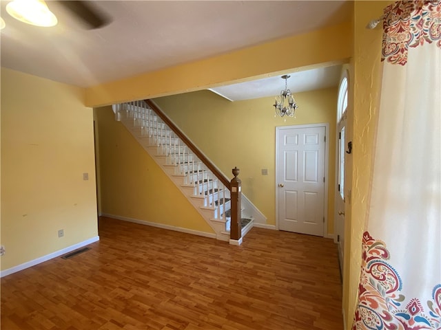 entryway featuring hardwood / wood-style flooring and a notable chandelier