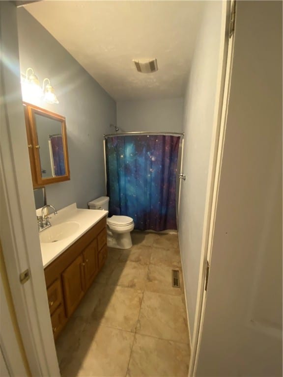 bathroom with vanity, toilet, a shower with curtain, and tile patterned floors