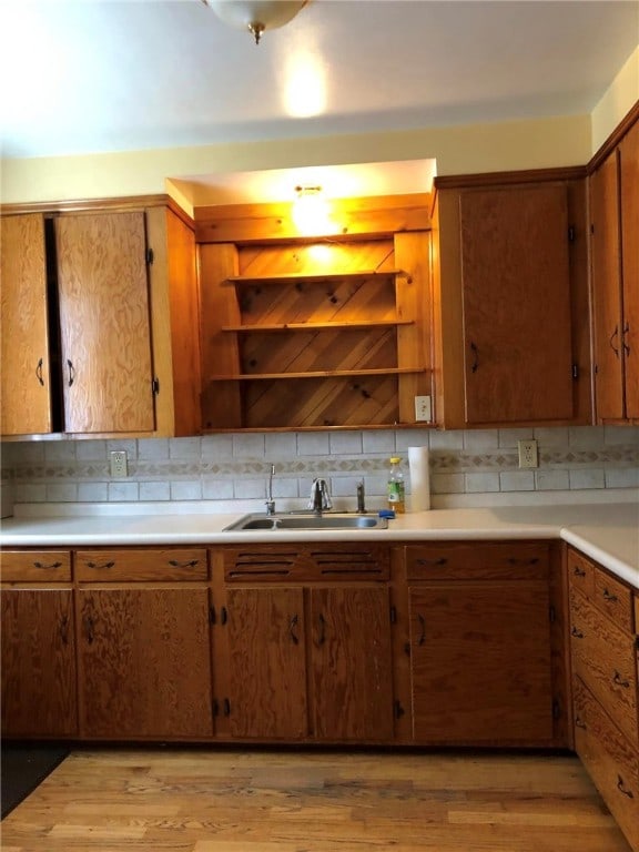 kitchen featuring tasteful backsplash, sink, and light hardwood / wood-style floors