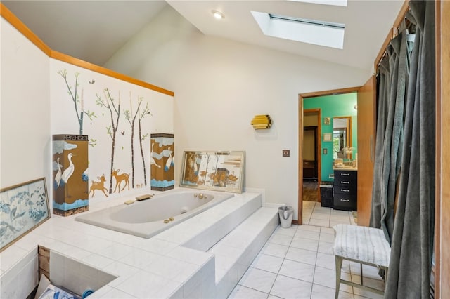 bathroom featuring vanity, vaulted ceiling with skylight, tile patterned floors, and tiled bath