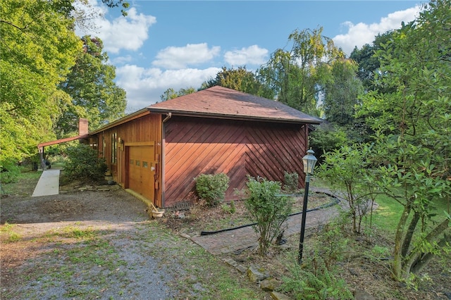 view of side of home featuring a garage and an outdoor structure