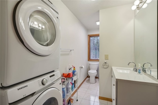 clothes washing area featuring light tile patterned floors, sink, and stacked washer and dryer