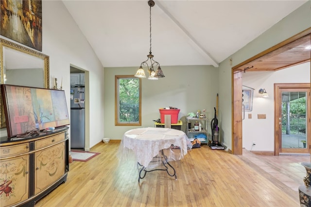 dining area featuring lofted ceiling, plenty of natural light, and light hardwood / wood-style floors