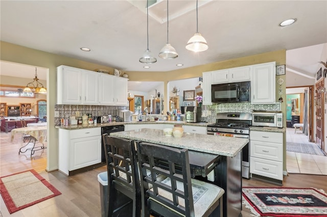 kitchen featuring black appliances, decorative light fixtures, white cabinets, and decorative backsplash