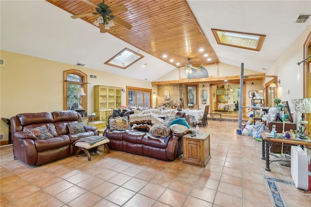 tiled living room featuring high vaulted ceiling, a skylight, ceiling fan, and wooden ceiling