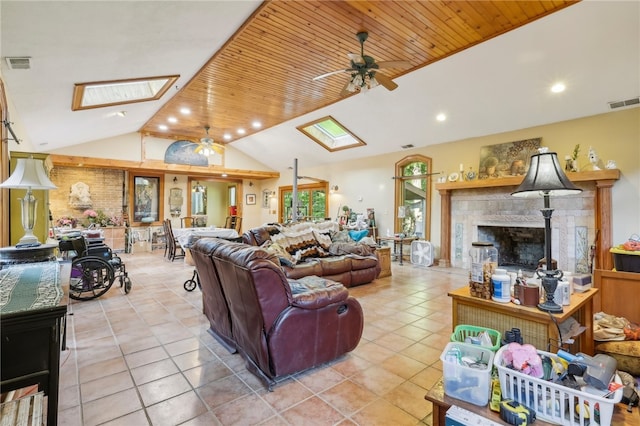 tiled living room featuring ceiling fan, wood ceiling, and vaulted ceiling with skylight