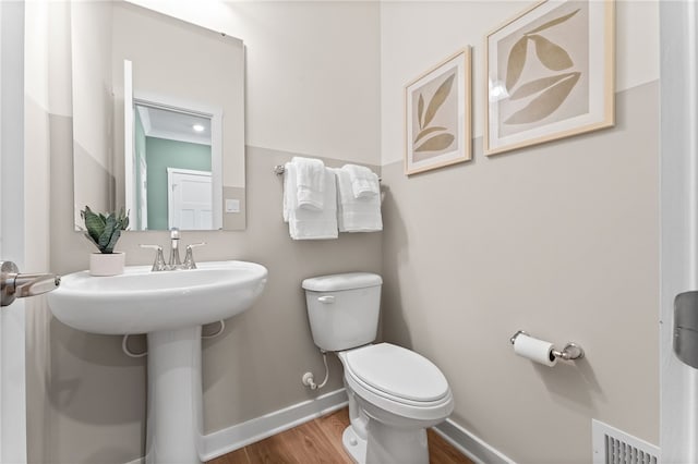 bathroom featuring hardwood / wood-style floors and toilet