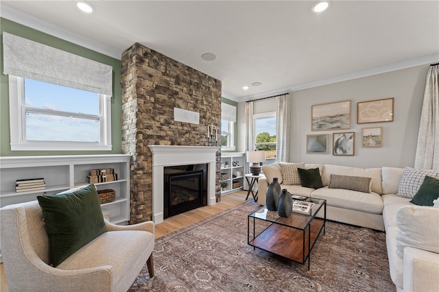 living room featuring a fireplace, ornamental molding, and wood-type flooring