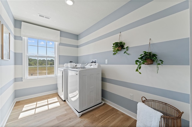 laundry room with light hardwood / wood-style flooring and washing machine and dryer