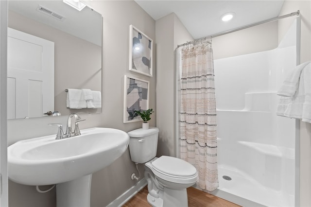 bathroom with curtained shower, hardwood / wood-style floors, toilet, and sink