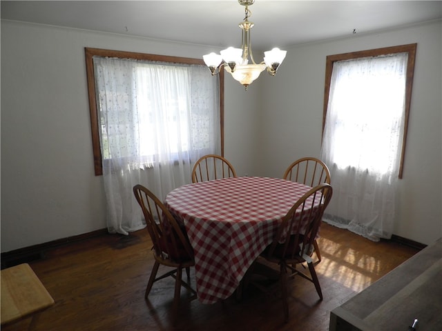 dining room with crown molding, dark hardwood / wood-style floors, and a chandelier