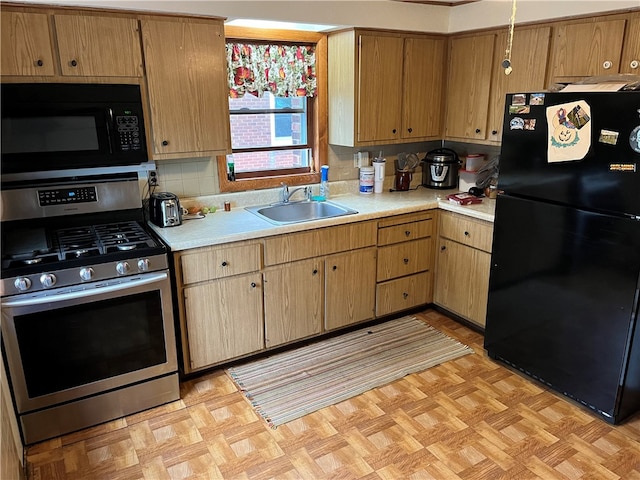 kitchen featuring tasteful backsplash, sink, light parquet floors, and black appliances