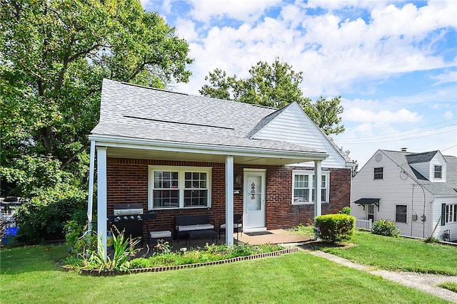 view of front of house with a front yard and covered porch