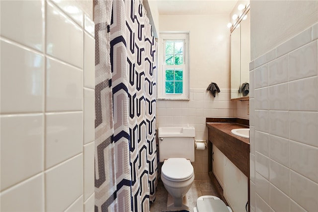 bathroom with tile patterned floors, tile walls, toilet, and vanity