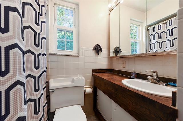 bathroom with tile walls, backsplash, toilet, and vanity