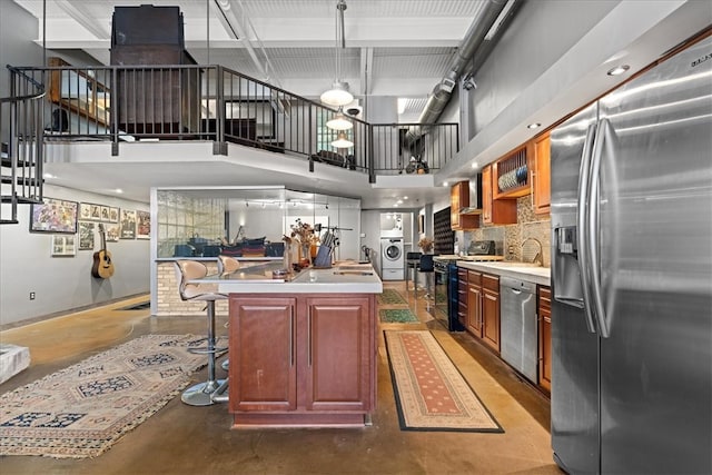 kitchen with a center island, hanging light fixtures, a breakfast bar, and appliances with stainless steel finishes