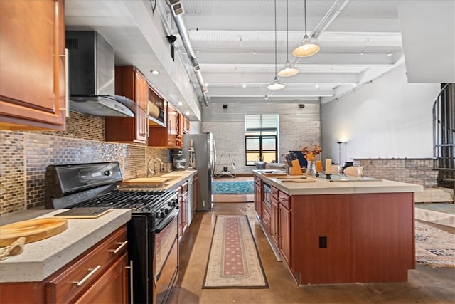 kitchen with decorative light fixtures, a center island, gas stove, wall chimney exhaust hood, and concrete flooring