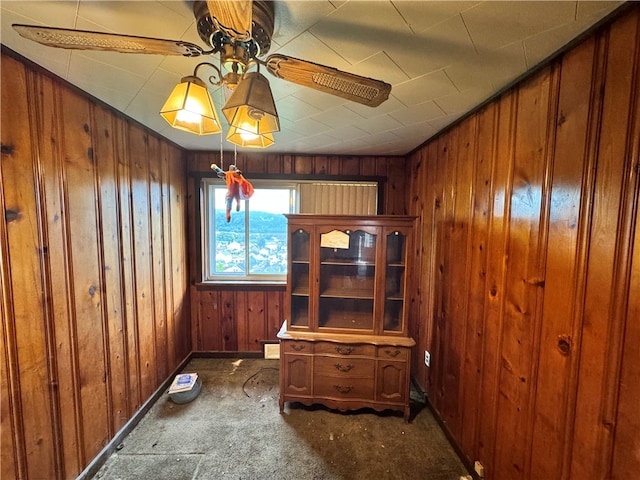 interior space featuring dark colored carpet and wooden walls