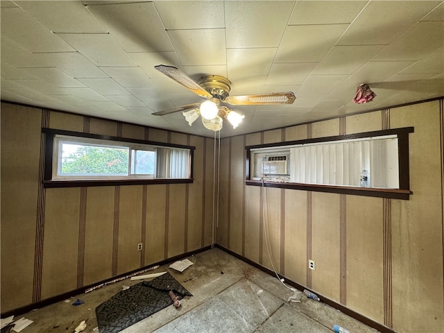 unfurnished room featuring wood walls and ceiling fan