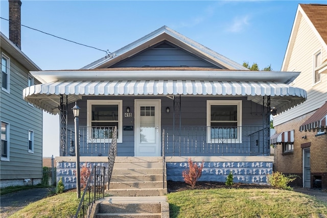 bungalow featuring a porch and a front lawn