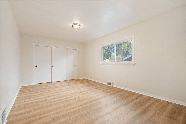 unfurnished bedroom featuring a closet and light wood-type flooring