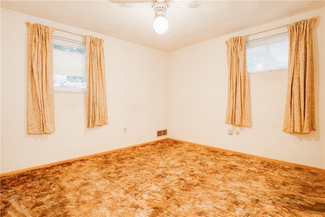 carpeted spare room featuring ceiling fan