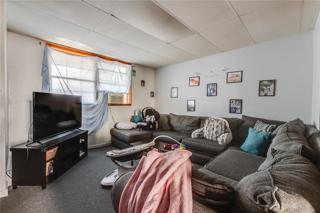 living room with a paneled ceiling and dark colored carpet