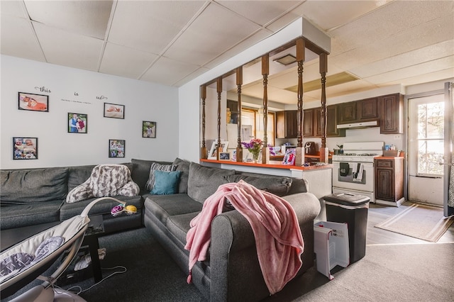 living room featuring a paneled ceiling and sink