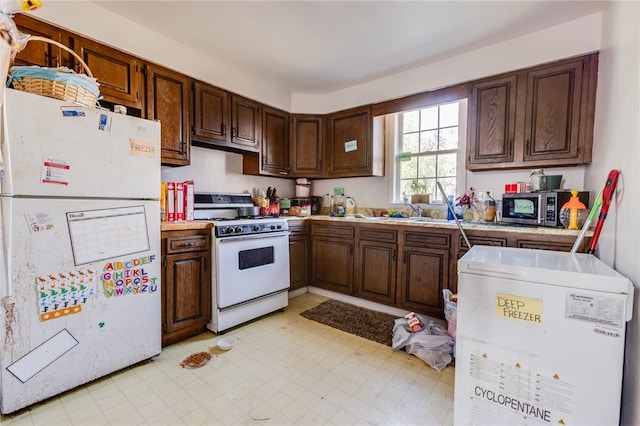 kitchen with white appliances and dark brown cabinetry