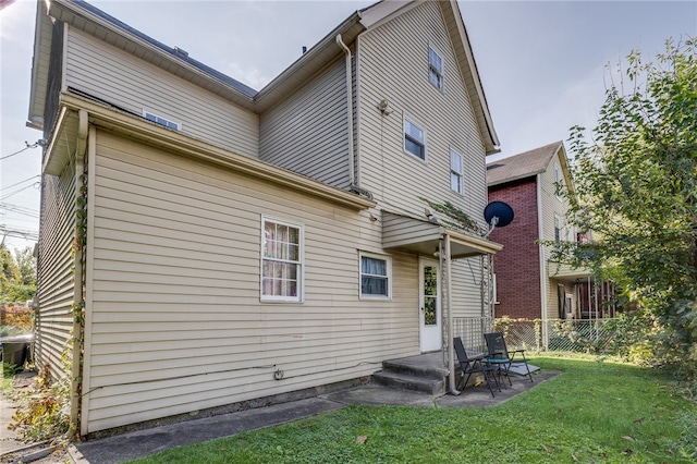 back of house featuring a lawn and a patio