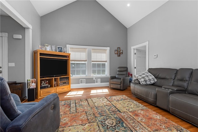 living room with high vaulted ceiling and hardwood / wood-style floors