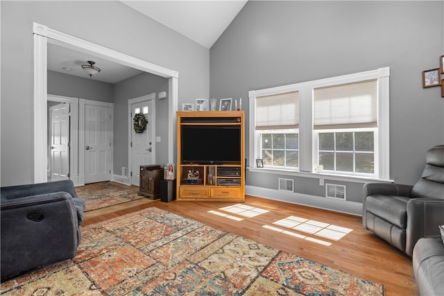 living room featuring lofted ceiling and hardwood / wood-style flooring