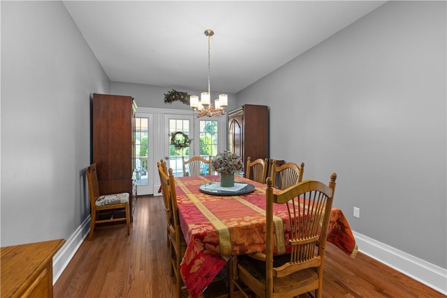 dining area featuring an inviting chandelier and dark wood-type flooring