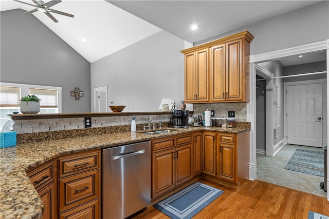 kitchen featuring light hardwood / wood-style floors, stone counters, high vaulted ceiling, ceiling fan, and stainless steel dishwasher