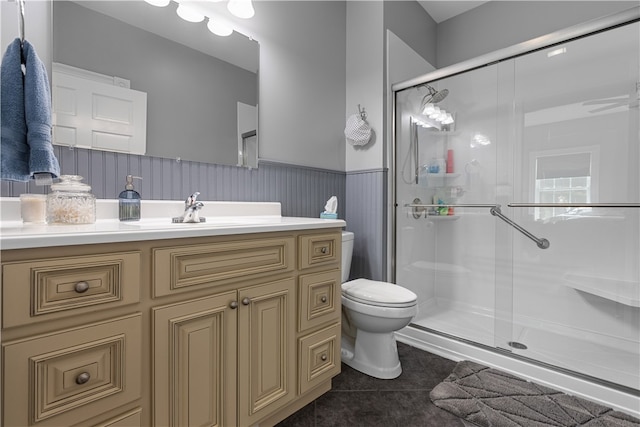 bathroom featuring tile patterned floors, walk in shower, vanity, and toilet