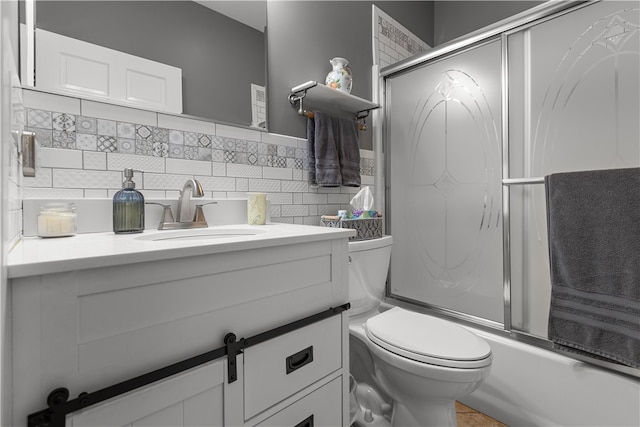 full bathroom featuring combined bath / shower with glass door, tasteful backsplash, vanity, and toilet